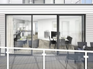 Um interior moderno com sala de jantar, cozinha e área de estar visíveis através de grandes portas de vidro deslizantes.