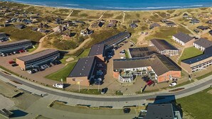 An aerial view of a coastal town with a mix of residential and commercial buildings, including a large parking lot and a prominent building with a sign that reads "Oceanview."