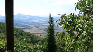 A view of a mountainous landscape with a stone wall and a wooden post in the foreground. - Villa With Pool in Sarteano (Chianciano Terme)