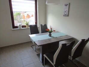Meetings take place in this functional room with a large table and four chairs, offering a view of the surrounding area.