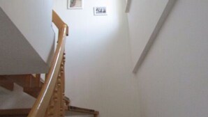 A wooden staircase with a handrail leading to a landing. - Holiday Apartment Hammann (Sietow)