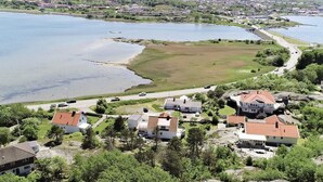 Et boligområde med huse ved en sø, samt en vej og en bro i baggrunden.