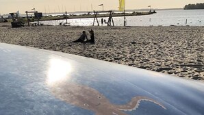 A beach with a large octopus design on a structure, a pier in the background, and a calm sea. - Cube Elite Noteboom 11 (Hulshorst)