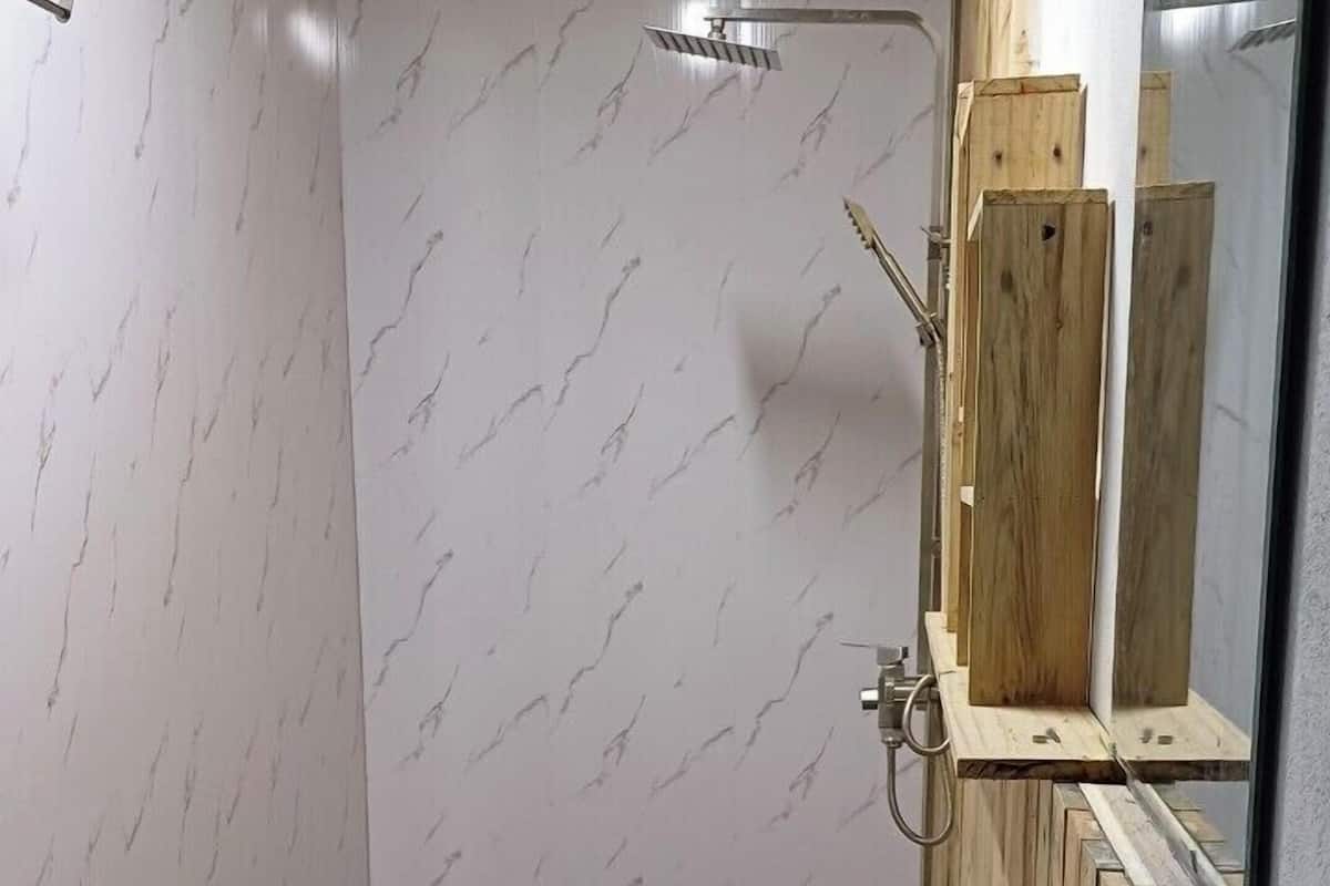 Un baño con lavamanos, inodoro y ducha blancos.