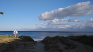 A beach path leading to the sea with a lifebuoy sign on the left. - 8 Person Holiday Home in Nykobing F (Nykøbing Falster)