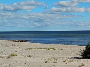 Una playa con cielos despejados y aguas tranquilas.