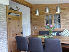 A wooden dining area with a table, chairs, and pendant lights. - Holiday Apartment Rubihorn (Oberstdorf)