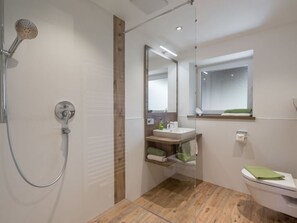 A modern bathroom with a shower, toilet, and sink. - Holiday Apartment Rubihorn (Oberstdorf)