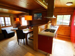 Cozy cabin-style room with a dining area, kitchenette, and seating area.