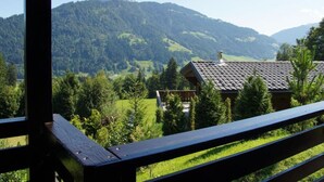 A wooden cabin with a tiled roof overlooking a mountainous landscape. - Grand Wastl Comfortable Holiday Residence (Woergl)