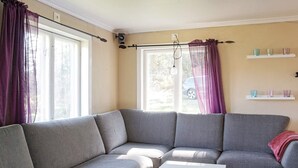A modern living room with a grey sectional sofa, a white coffee table, and a window with curtains. - 6 Person Holiday Home in Fjallbacka (Fjallbacka)