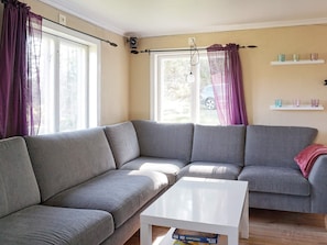 A modern living room with a grey sectional sofa, a white coffee table, and a window with curtains. - 6 Person Holiday Home in Fjallbacka (Fjallbacka)
