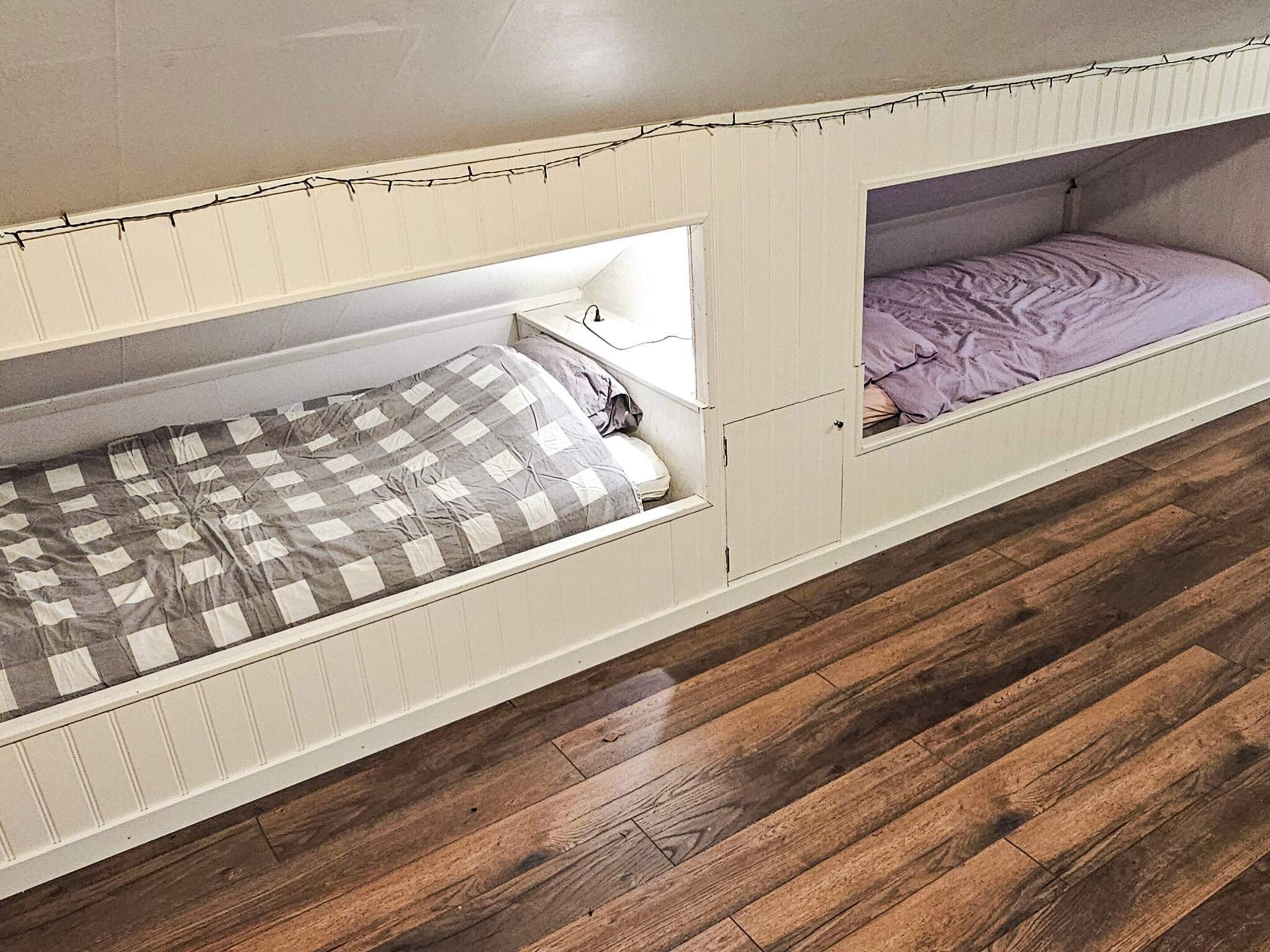 Una habitación con dos literas, suelo de madera y ventana con vistas.