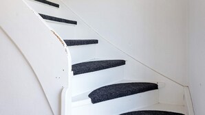 A white staircase with black risers and a white wall. - 6 Person Holiday Home in Fjallbacka (Fjallbacka)
