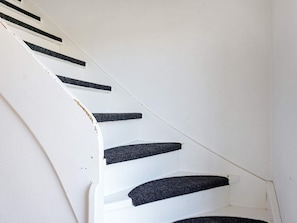 A white staircase with black risers and a white wall. - 6 Person Holiday Home in Fjallbacka (Fjallbacka)