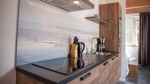 Una cocina moderna con encimera de madera, estufa integrada y cafetera.
