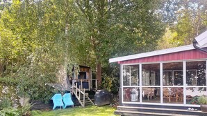 A house with a covered porch, a small deck, and a grassy yard with two blue chairs. - 7 Person Holiday Home in Tjorn-by Traum (Myggenäs)