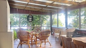 A covered porch with wicker furniture, large windows, and a hanging lantern. - 7 Person Holiday Home in Tjorn-by Traum (Myggenäs)