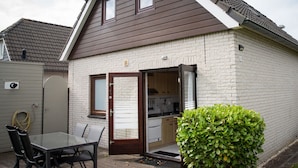 Einbungalow mit einem braunen Dach, einer Ziegelaußenfassade und einem sichtbaren Küchenbereich.