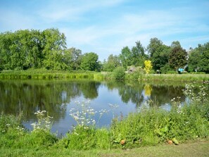 A calm lake surrounded by lush greenery and trees. - Jessen Modern Retreat (Gelting)