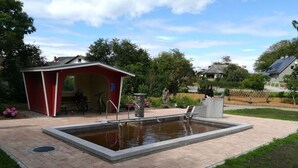 A swimming pool with a red pavilion and a stone fountain. - Jessen Modern Retreat (Gelting)
