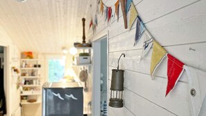 A narrow hallway with a wooden floor, a refrigerator, and a wall adorned with colorful pennant flags. - 5 Person Holiday Home in Djurhamn-by Traum (Djurhamn)