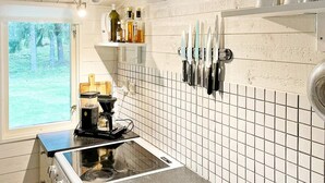 A kitchen with a gas stove, coffee maker, and knives hanging on the wall. - 5 Person Holiday Home in Djurhamn-by Traum (Djurhamn)