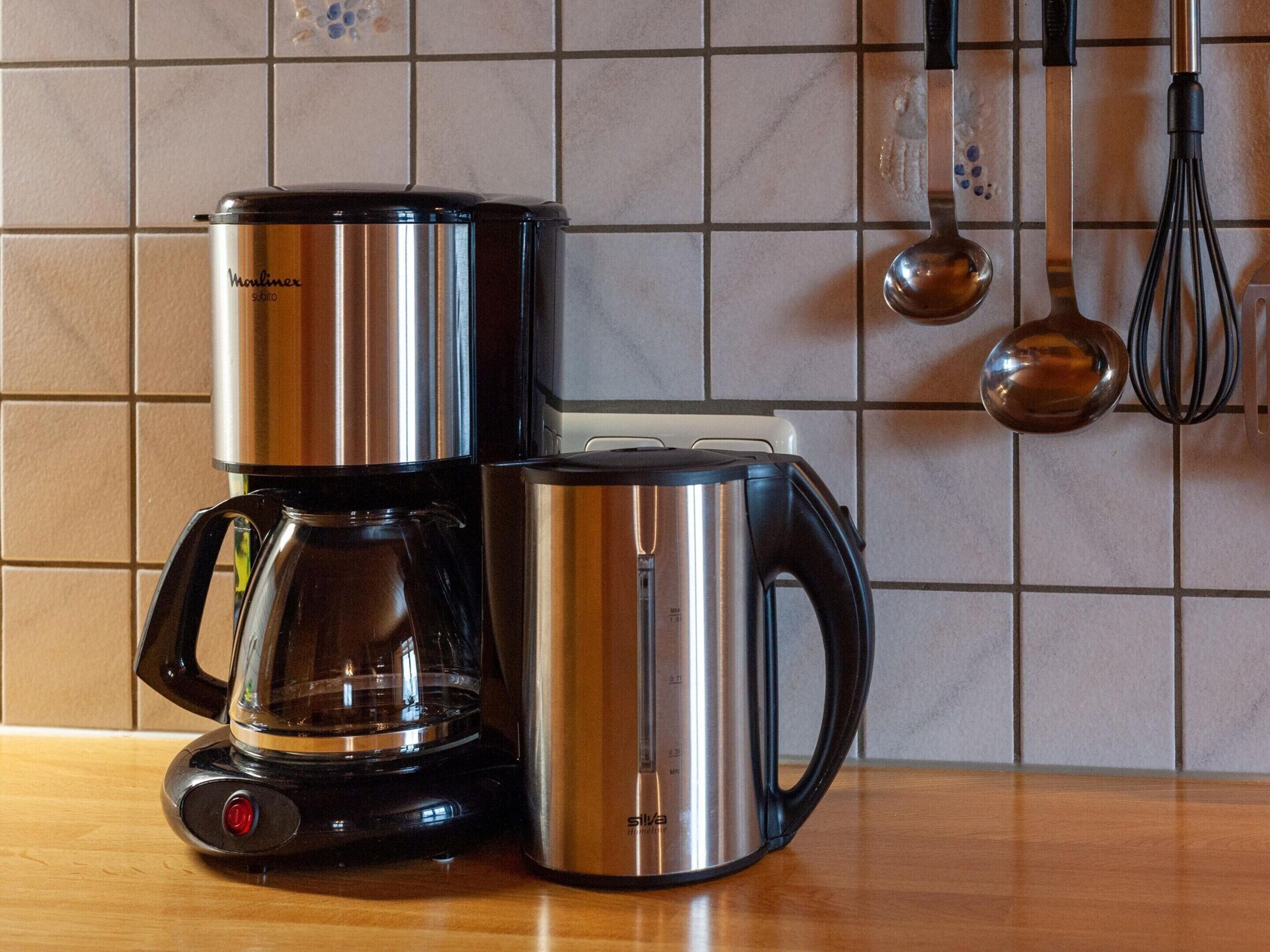 Une machine à café et une bouilloire sur le plan de travail de la cuisine.
