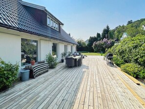 A wooden deck with outdoor furniture, a barbecue grill, and potted plants. - 6 Person Holiday Home in Askim-by Traum (Askim)