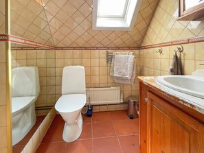 Un baño con inodoro, lavamanos, radiador y ventana.