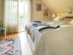 A bedroom with a bed, a chair, a lamp, and a window with curtains. - 6 Person Holiday Home in Askim-by Traum (Askim)