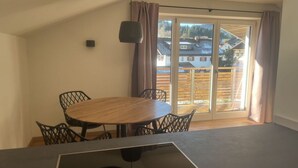 A dining area with a round table and chairs, a ceiling light, and a sliding glass door leading to an outdoor deck. - 1 Porzig Modern Retreat (Fischen im Allgaeu)