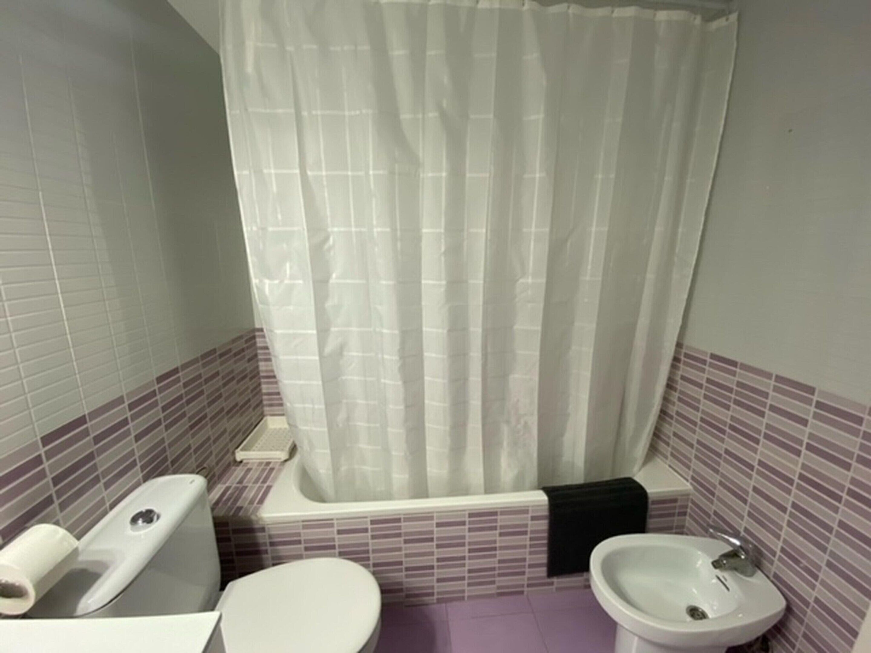 Un baño con inodoro, bidé, bañera y lavabo.