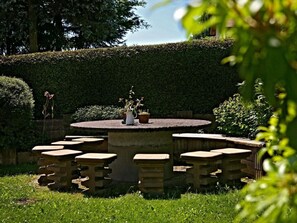 Relax in a serene garden setting with a circular table and six benches.