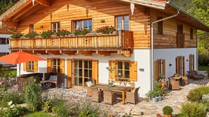 A wooden chalet with a balcony, outdoor seating, and a garden. - Holiday Apartment Dosbach (Reit im Winkl)