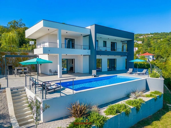 A modern two-story house with a swimming pool, outdoor seating, and a barbecue area. - Ziganto Comfortable Holiday Residence (Opatija)
