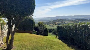A well-maintained garden with a clear view of rolling hills in the distance. - >>casa Conil Buena Vista<< (Conil de la Frontera)