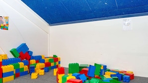 Una habitación con bloques de construcción coloridos esparcidos sobre el suelo y un techo azul.