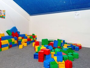 A room with scattered colorful building blocks on the floor and a blue ceiling. - 6 Person Holiday Park Home in Ebeltoft (Ebeltoft)