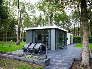 A modern, glass-walled building with a minimalist design, surrounded by a lush green park. - 6 People Pet-free Comfortable Vacation Home (Zorgvlied)