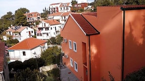 A residential area with houses featuring red-tiled roofs and white walls. - Apartments St Rialto - Comfort One-bedroom Apartment With Balcony and Sea View (Jelsa)