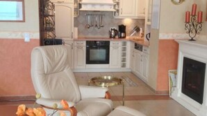 A modern living room with a beige leather sofa, a coffee table, and a fireplace. - 55, Apartment House "bel-vital" (Binz)