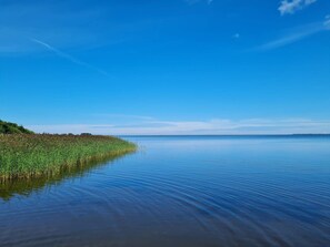 A calm lake with a clear sky and a distant shoreline. - 4 Person Holiday Home in Ulfborg (Ulfborg)