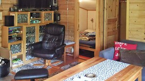 A cozy cabin interior with a wooden chair, a small table, a sofa, and a bunk bed. - 11 Person Holiday Home in Gjesdal-by Traum (Gjesdal)