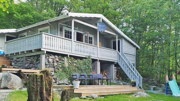 A two-story house with a balcony, a stone foundation, and a wooden deck. - 11 Person Holiday Home in Gjesdal-by Traum (Gjesdal)