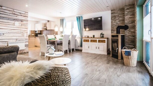 A modern living room with a dining area, a kitchen, and a fireplace. - A gem of a Modern Retreat (Oberharz am Brocken)