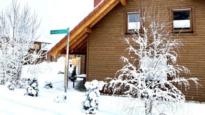 A wooden cabin with a sloped roof, a visible chimney, and a window. Snow covers the ground and trees. - A gem of a Modern Retreat (Oberharz am Brocken)