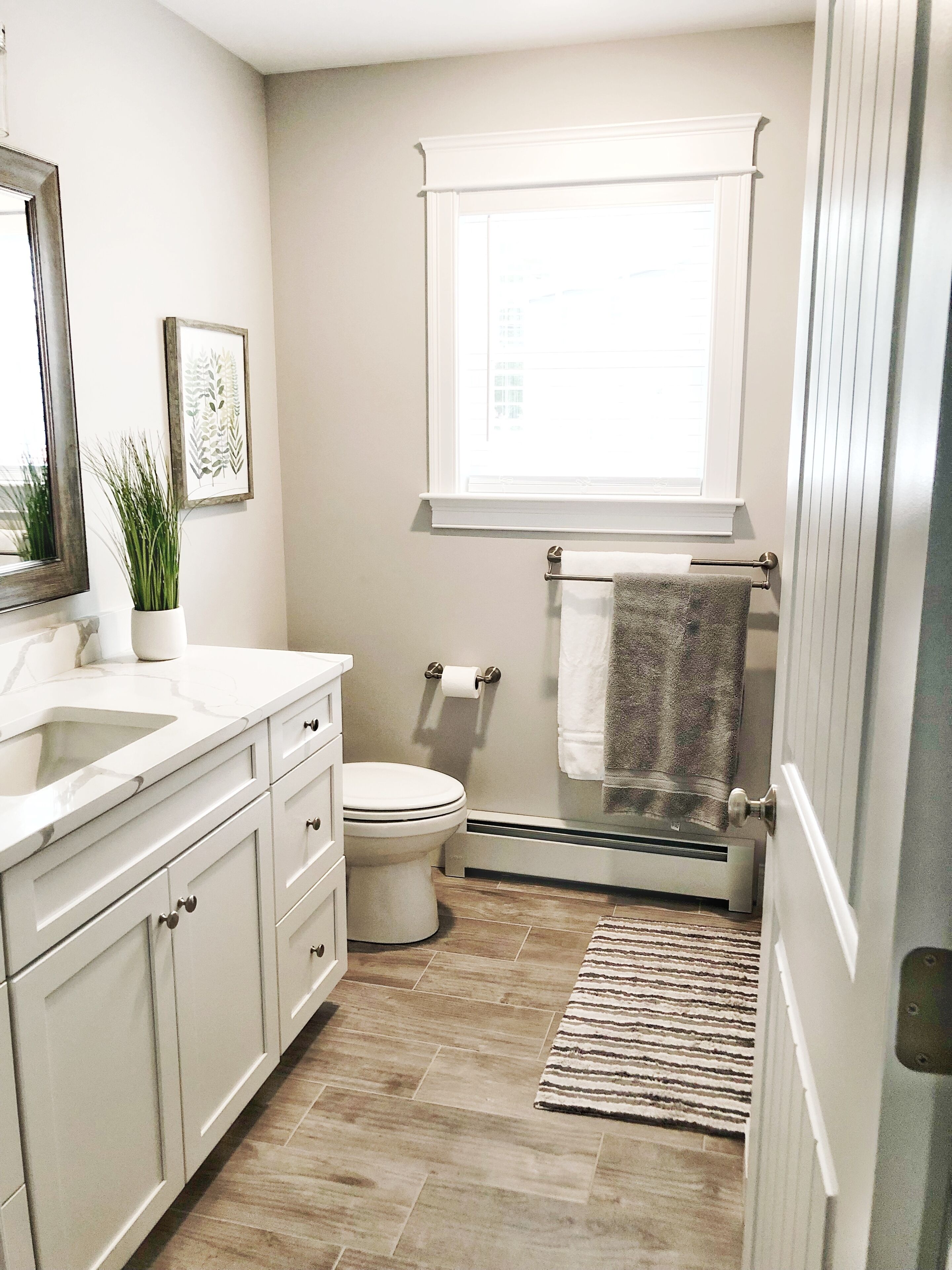 Une salle de bain équipée de toilettes, d’un lavabo, d’un miroir et d’une fenêtre.