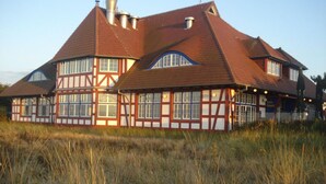 A traditional half-timbered building with multiple windows and a sloped roof.