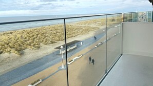 A balcony with a view of the beach, sandy dunes, and the sea. - Apartment in Nieuwpoort Near the Beach (Nieuwpoort)